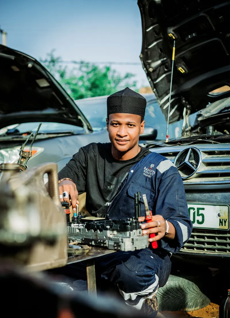 A smiling mechanic at work on a car
